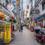 Bustling evening street in Seoul with traditional signage, people, and warm lighting.
